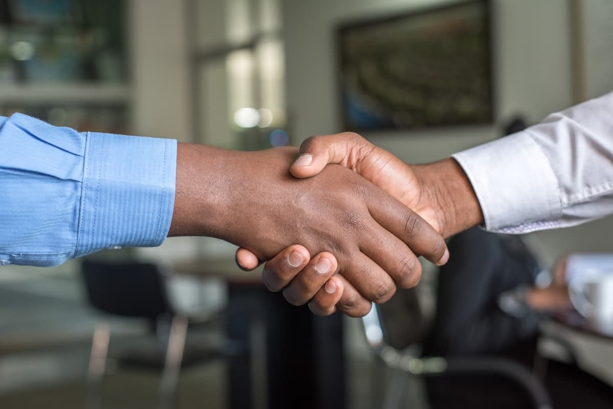 Advisor and client shaking hands after a compliance review
